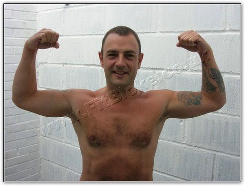 Robin shirtless, flexing both arms, end of Month One, September 2005