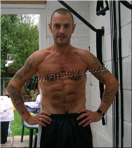 Robin in August 2006, shirtless, lean with visible abs, hands on hips in his garden gym