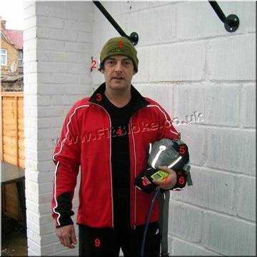 Robin in a red running jacket and green beanie, holding his running kit